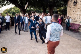   An attempted breadstick toss humorously misses its mark at Domaine de Vavril, Beaujeu, Rhône, France, adding an unconventional twist to the wedding celebration.